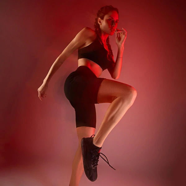 Mulher em salto com o joelho alto usando o Barefoot Ultra preto