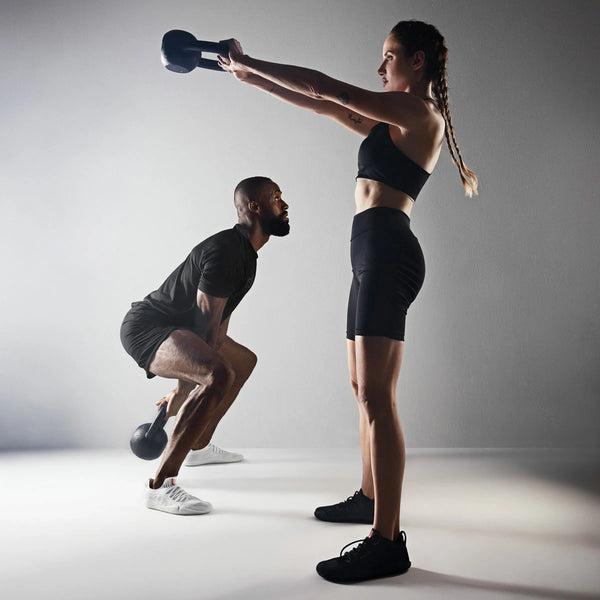 Homem e mulher treinando com kettlebell usando o Barefoot Ultra